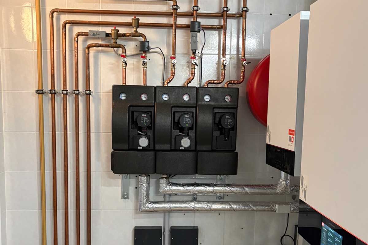 Heizungsanlage mit Pumpengruppen und Kupferrohrleitungen im Technikraum